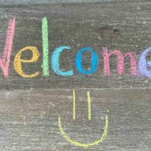 Le mot welcome écrit à la craie de toutes les couleurs
