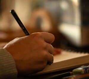Main de l'écrivaine tenant un stylo et écrivant